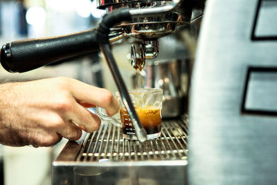 Close-up of man pouring coffee in cafe