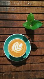 Coffee cup and leaves on table