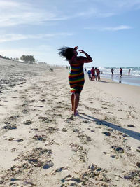 Full length of woman on beach against sky