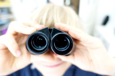 Close-up of woman holding binoculars