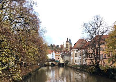 River amidst buildings in city against sky