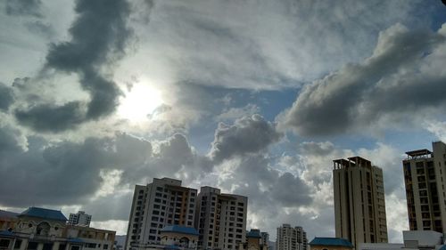 Low angle view of buildings against cloudy sky