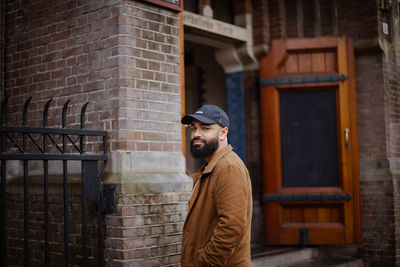 Side view of man standing against wall