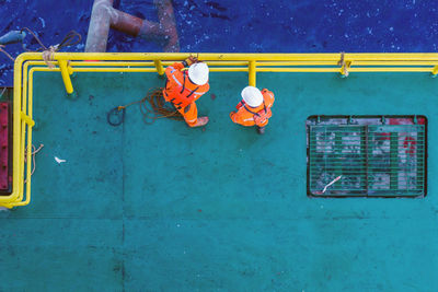 Offshore workers preparing sling and rigging for anchor handling at construction  barge at oil field