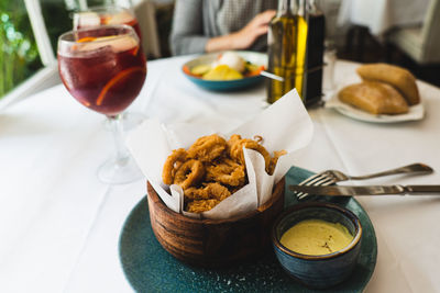 Fried calamari with dip sauce and glasses of sangria. eating lunch at an elegant restaurant