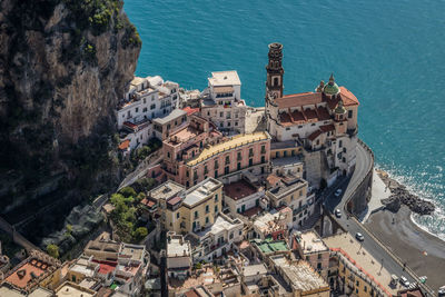 High angle view of houses on mountain by sea during sunny day