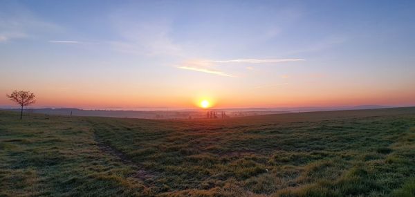 Scenic view of field against sky during sunset