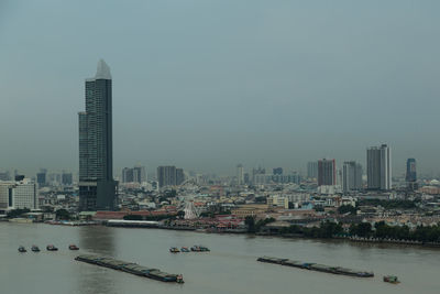 City at waterfront against clear sky