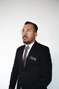 Portrait of man standing against white background