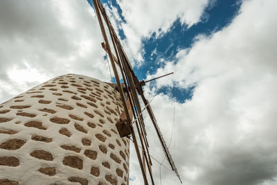 Low angle view of windmill against cloudy sky