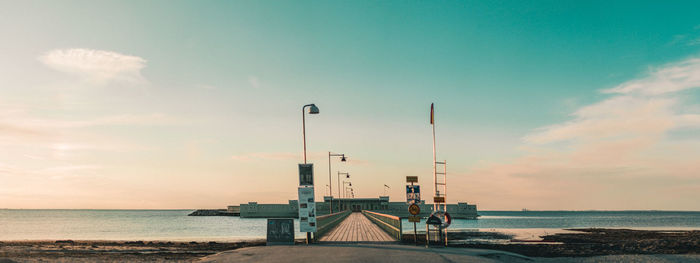 Panoramic view of pier at beach against sky