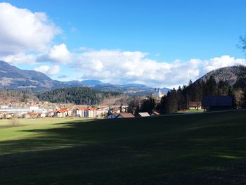 Scenic view of golf course against blue sky