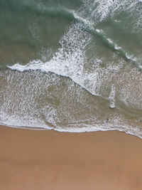 High angle view of waves rushing towards shore