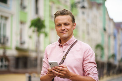 Young man using mobile phone in city