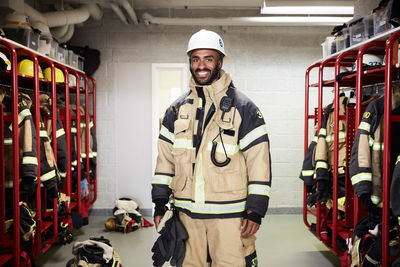 Portrait of smiling male firefighter in locker room at fire station