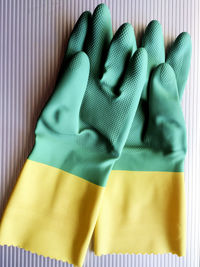 Close-up of green and yellow rubber gloves on table