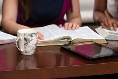 Midsection of woman reading book