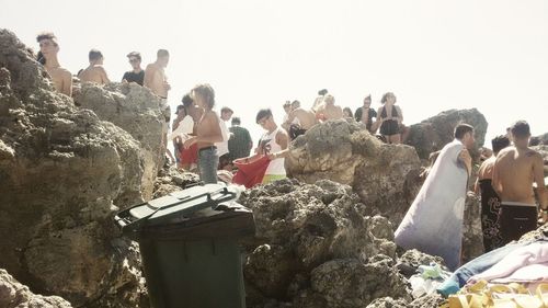 People at beach against clear sky