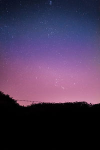 Scenic view of landscape against star field at night
