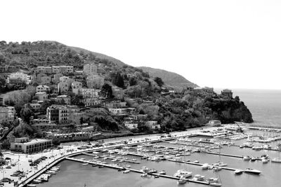 High angle view of townscape by sea against clear sky