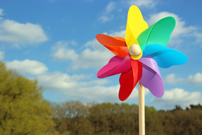 Multi colored pinwheel toy against sky
