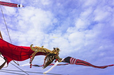 Low angle view of decorations waving against sky