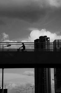 Low angle view of silhouette bridge against sky in city