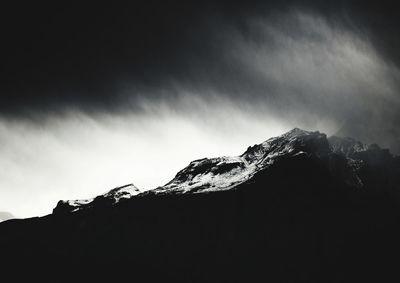 Low angle view of snowcapped mountain against sky