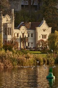 Lake and buildings against trees in city