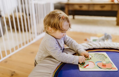 Side view of girl playing with toys at home