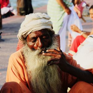 Sadhu smoking cigarette while sitting outdoors