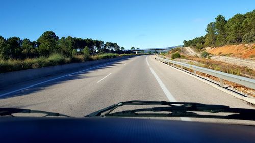 Road against clear blue sky