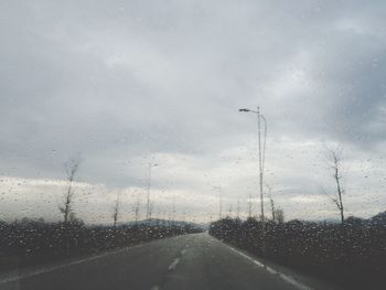 Road seen through wet windshield during rainy season