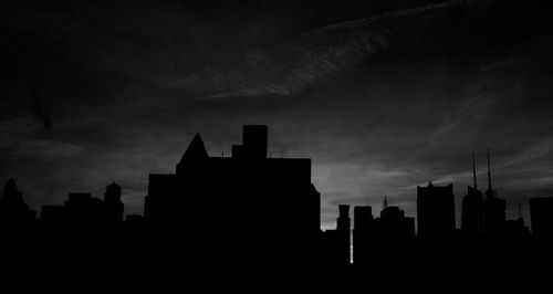Silhouette of buildings against sky at sunset