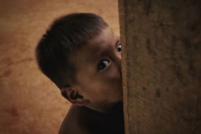 Close-up portrait of boy looking away against wall