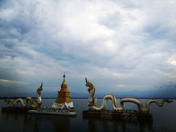 Statue of temple against cloudy sky