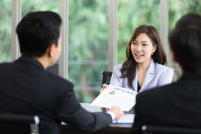 Colleagues sitting on table at office