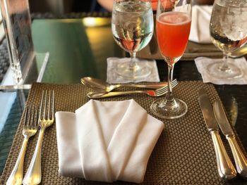 Midsection of wine glasses on table at restaurant