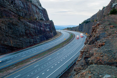 Road by mountains against sky