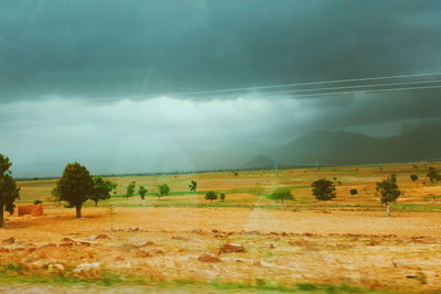 Scenic view of field against cloudy sky