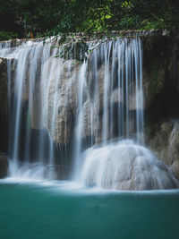 Scenic paradise waterfall tides close up with turquoise pond. erawan falls, kanchanaburi, thailand.