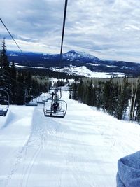 Ski lift over snow covered mountains