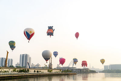 Hot air balloons flying in sky over city