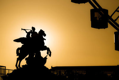 Silhouette of statue at sunset