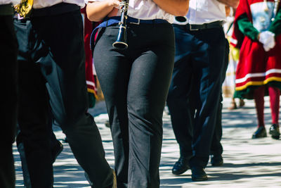 Rear view of people standing on street in city