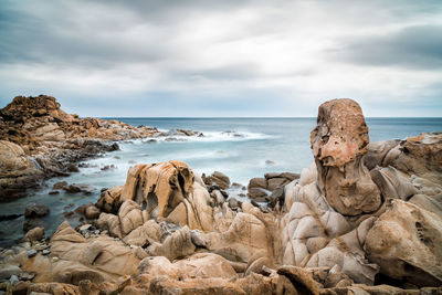 Rocks on beach against sky