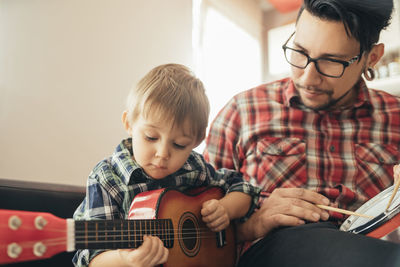 Father and son playing toy musical instruments