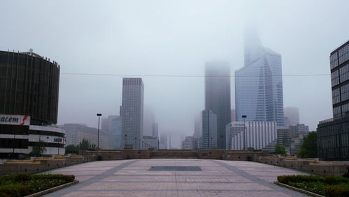 View of tiled lobby with buildings against sky in city