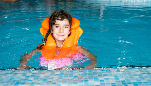 Portrait of young woman swimming in pool