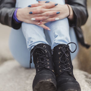 Low section of woman sitting on rock